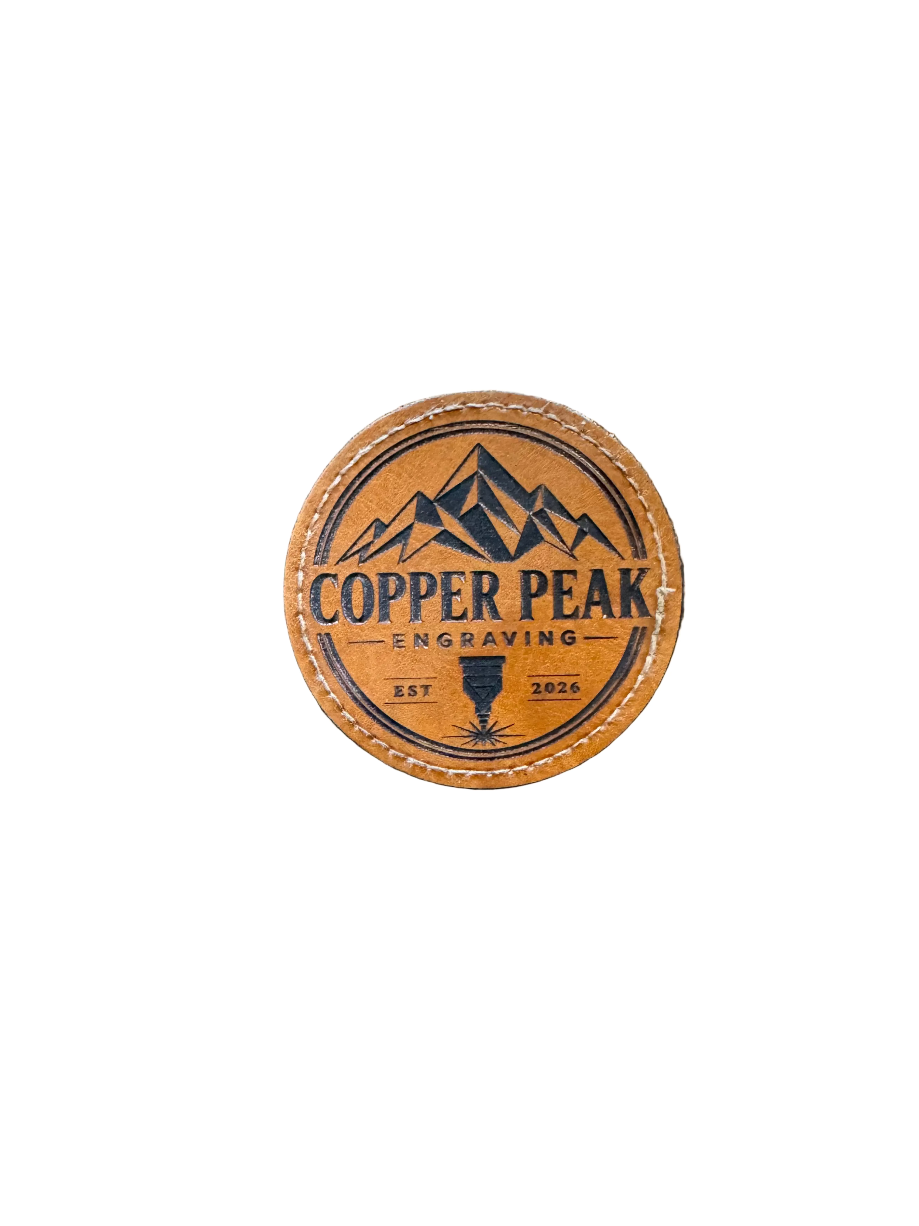 Circle leather hat patch engraved with the Copper Peak Engraving logo